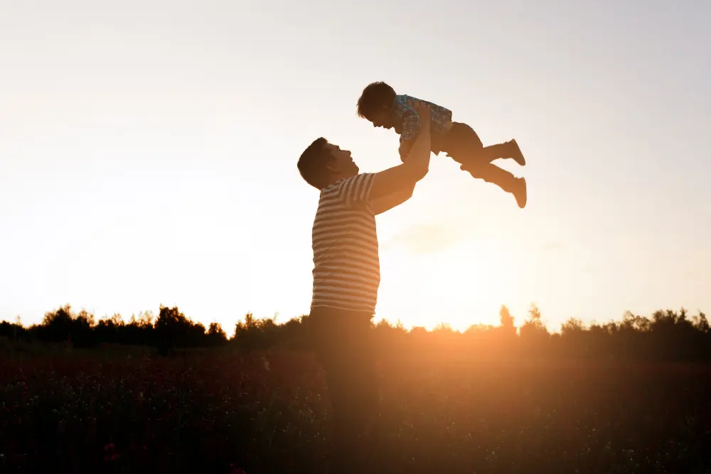 Pai e filho em um momento de afeto durante o pôr do sol - Foto: Freepik

