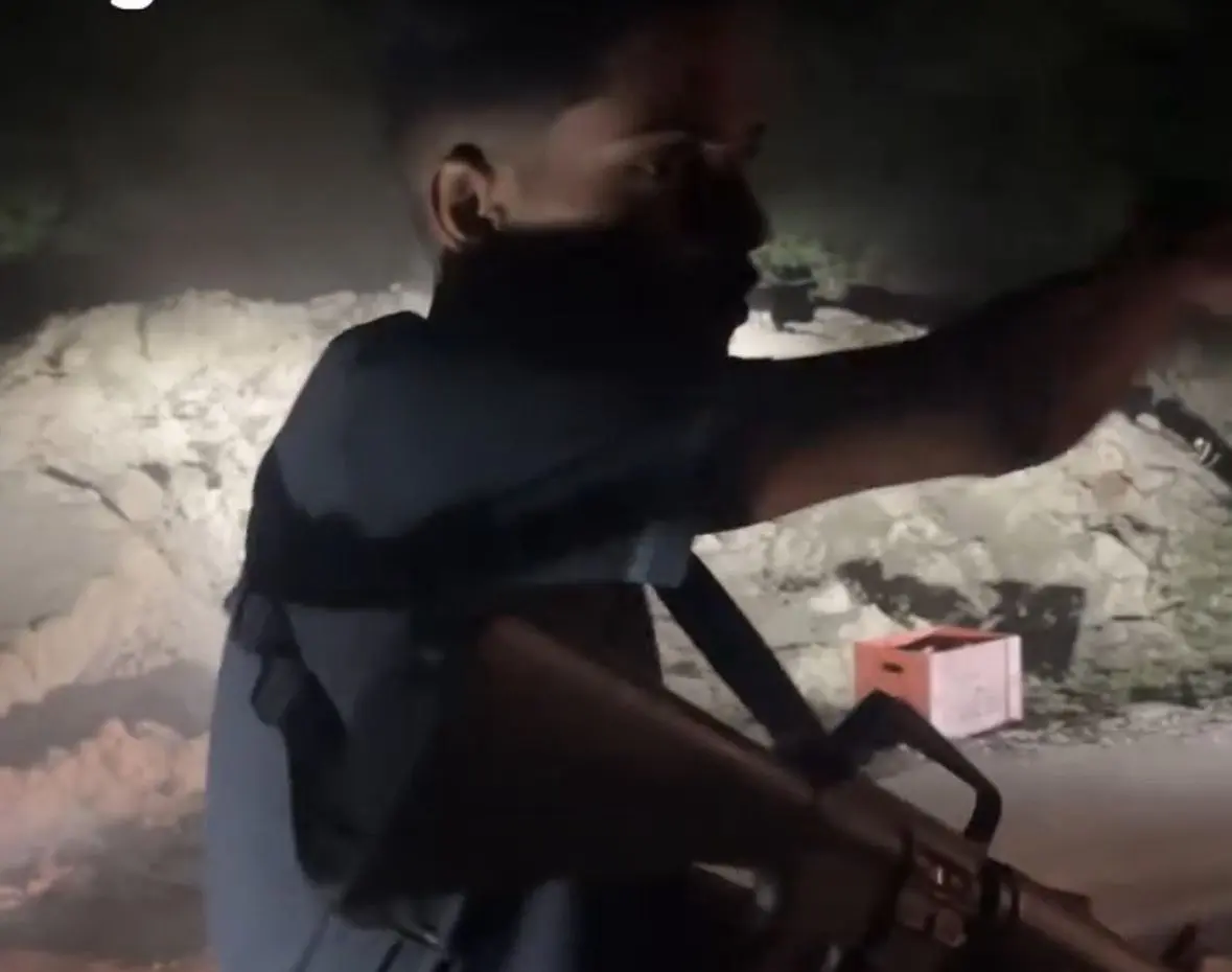 Traficantes aparecem em vídeo ensinando a novos membros do CV a usar um fuzil (Foto: Reprodução/Redes sociais)