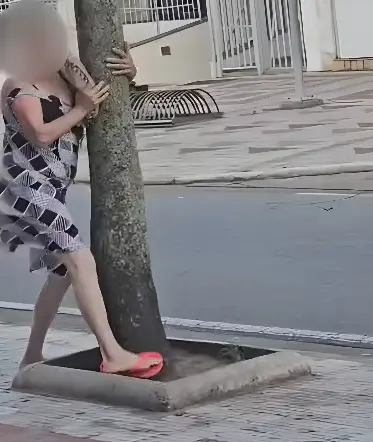 Mulher segura em árvore para não ser levada por ventania de ciclone (Foto: Reprodução)