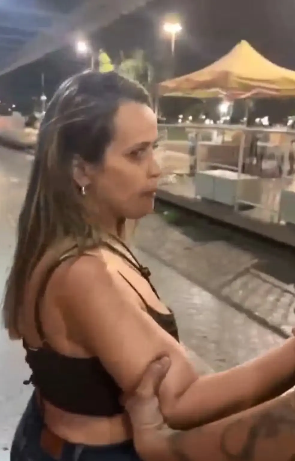 Momento da confusão na saída de festa no Conic, em Brasília; professora aparece agredindo e proferindo ofensas racistas contra a vítima. Foto: Reprodução.