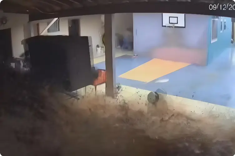 Muro despenca por conta de enxurrada e mulher corre para se salvar (Foto: Reprodução Câmera de Segurança)