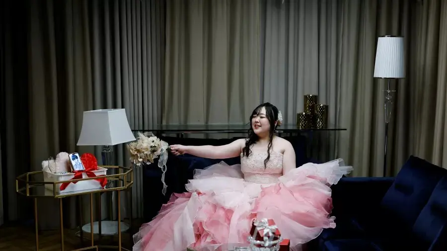 Yurina Noguchi, de 32 anos, posa com buquê durante cerimônia simbólica de casamento com “Klaus”, personagem de IA exibido em seu celular, em Okayama, no Japão. Foto: Kim Kyung- Hoon.