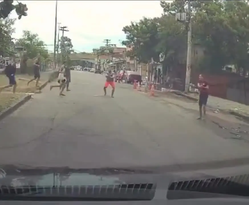 Criminosos armados atravessam a Rua Leopoldo Bulhões e param o trânsito durante fuga após operação que resgatou caminhoneiro sequestrado, na Zona Norte do Rio. Foto: Reprodução.