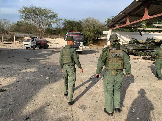 circulam por área destruída dentro de uma prisão venezuelana após operação militar; veículos e equipamentos pesados permanecem no local. Foto: Reprodução.