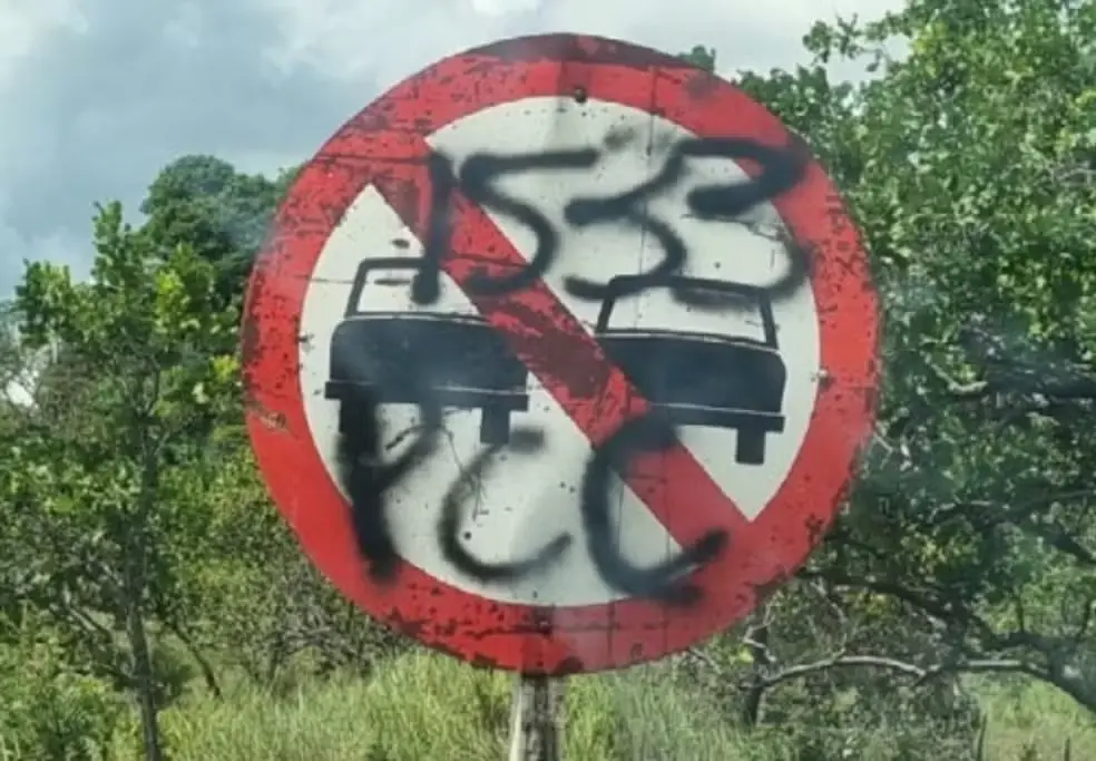 Placa de trânsito na RR-205, que dá acesso a Terra Indígena Raposa Serra do Sol, pinchada com sigla do PCC. — Foto: Fórum Brasileiro de Segurança Pública/Reprodução