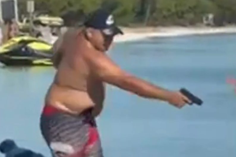 Banhista flagrado apontando arma para velejador